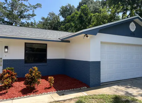 The same Daytona Beach house finished in white with a blue painted block base, gable and fascia