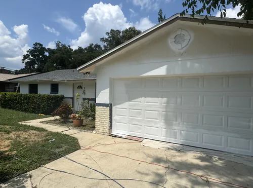 Daytona Beach block house part way through an exterior repaint, first white coat on the walls and trim not yet painted