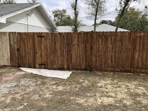 The same South Daytona backyard wood fence and gate finished in an even brown stain
