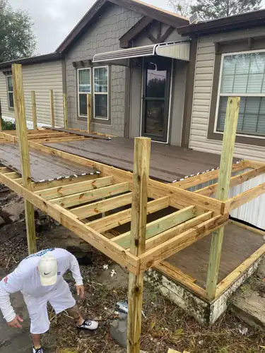 The same Port Orange deck part way through staining, with some decking boards stained brown and the frame and railings still bare wood